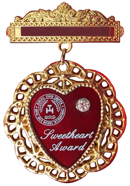 Gold sweetheart award medal with red heart center and decorative filigree border
