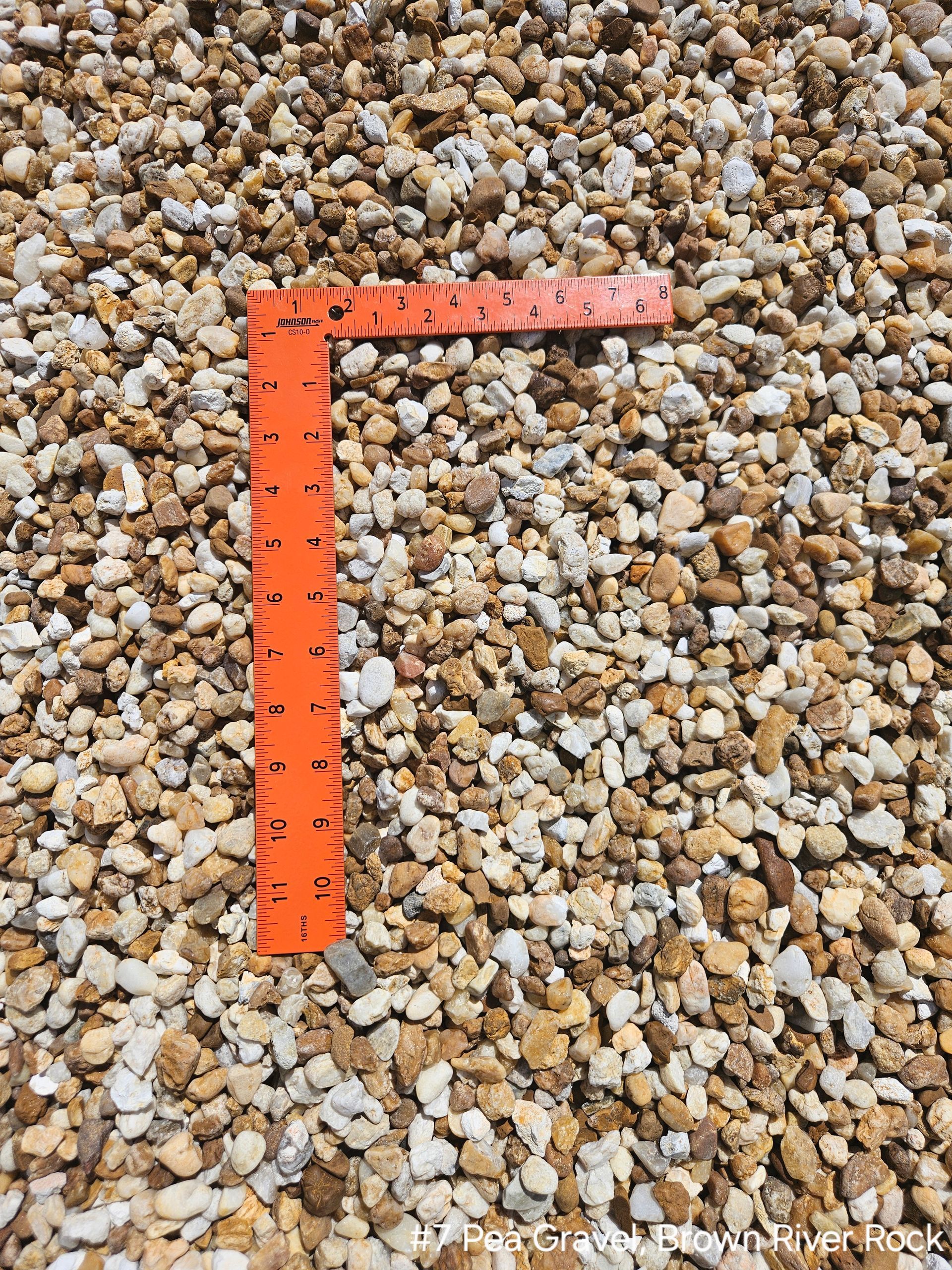 Orange ruler on a bed of tan and white gravel.