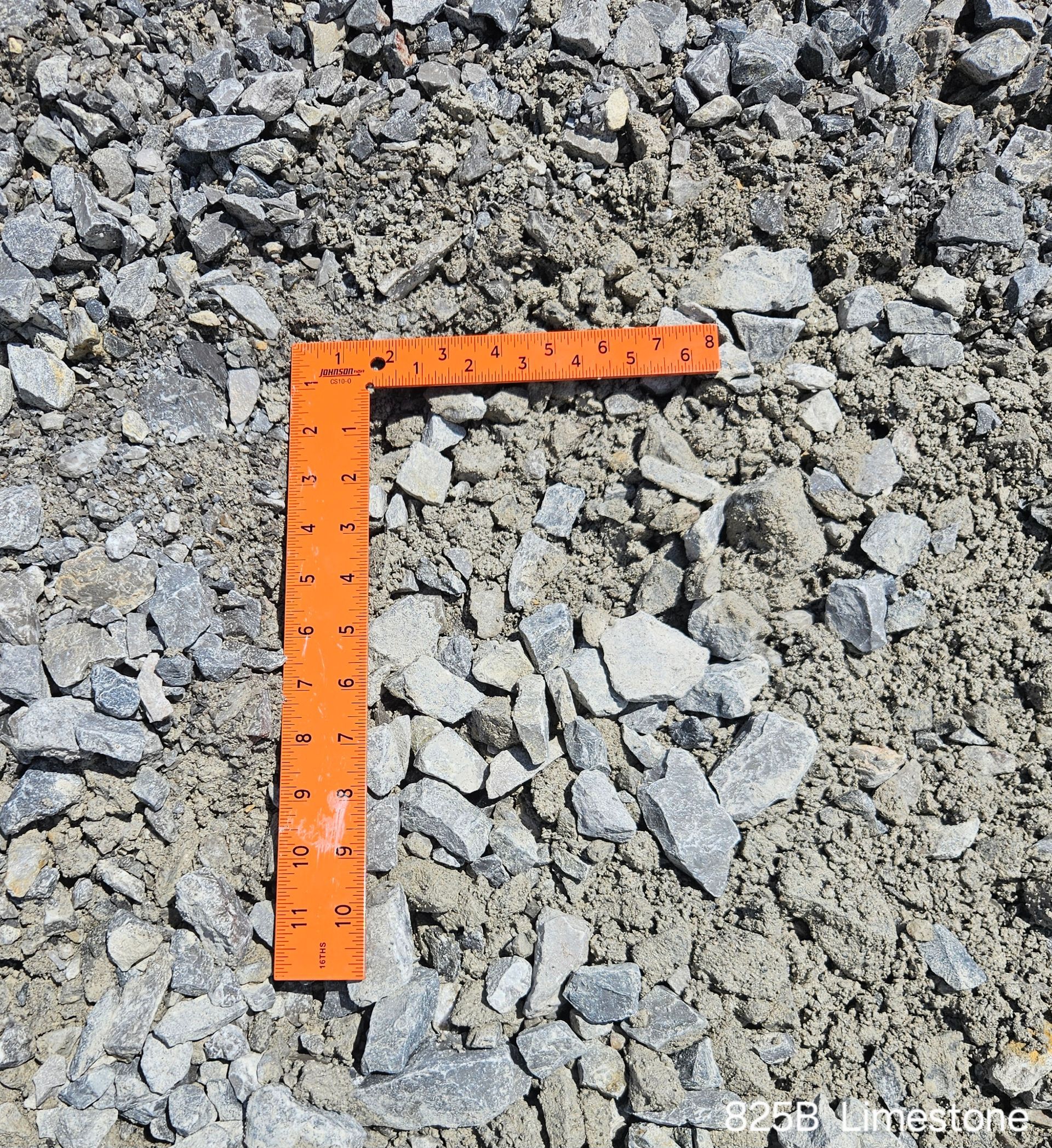 Gray gravel with an orange ruler, showing the scale of the rocks.