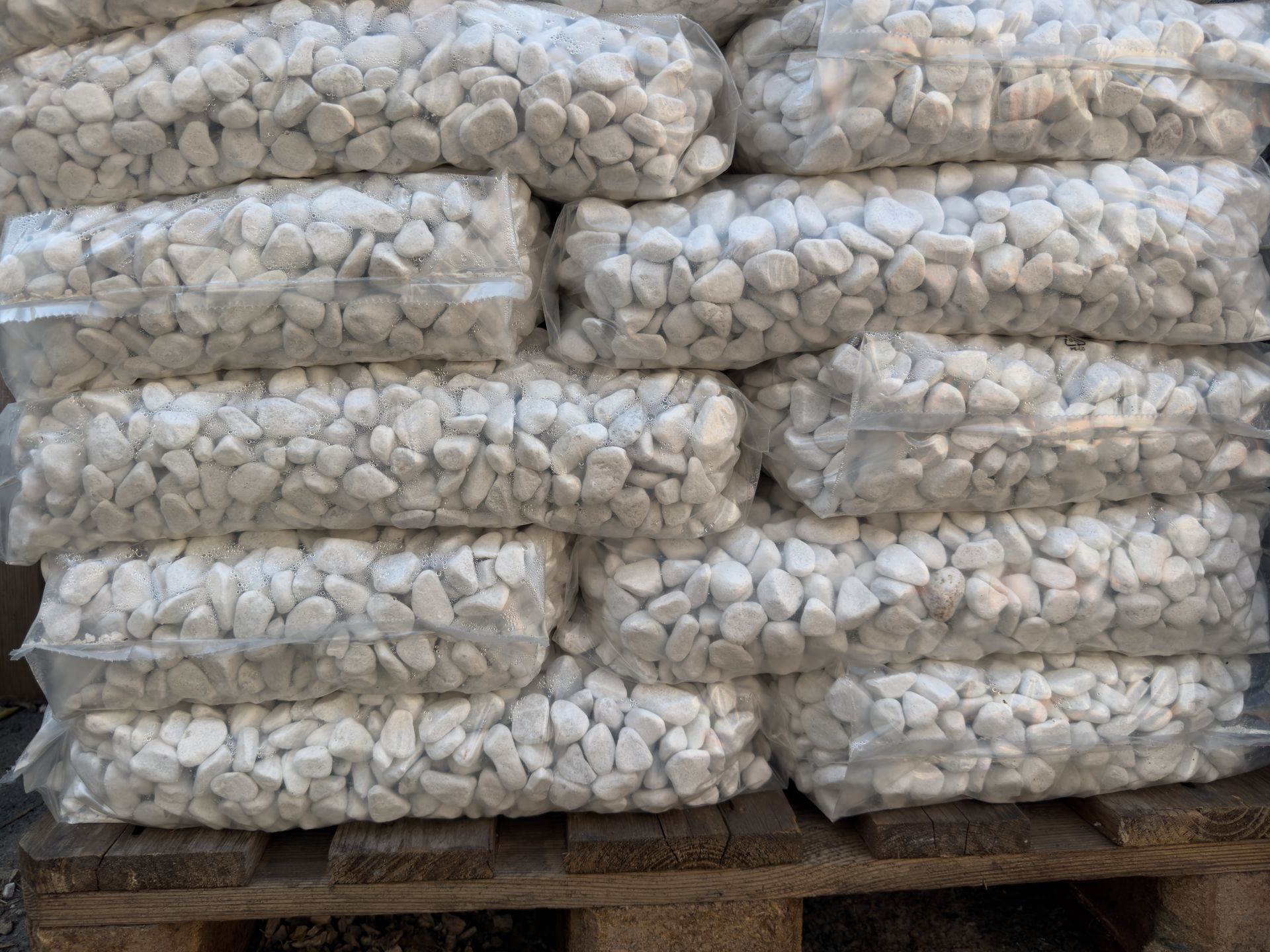 Bulk white pebbles packaged in plastic bags for transport. Bulk white pebbles packaged in plastic bags for transport.