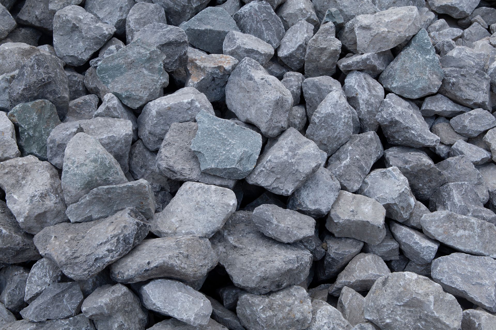 A pile of gray crushed stone gravel used for construction, drainage, or landscaping. A pile of gray crushed stone gravel used for construction, drainage, or landscaping.