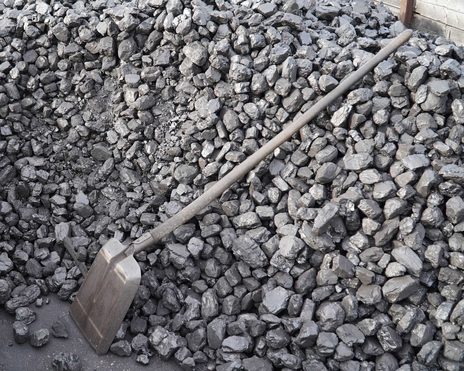 A gravel shovel is laid against a pile of construction stone. A gravel shovel is laid against a pile of construction stone.
