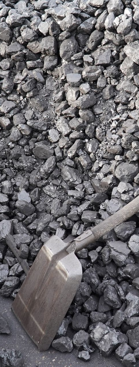 A gravel shovel is laid against a pile of construction stone. A gravel shovel is laid against a pile of construction stone.