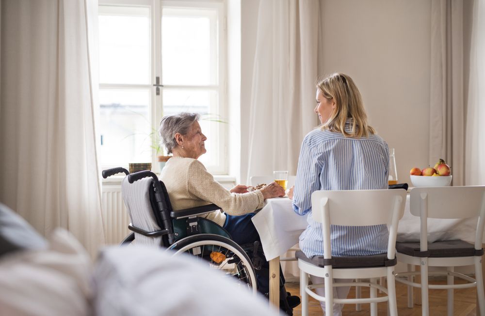 a senior man with an intellectual and physical disability vacuuming the floor of his home