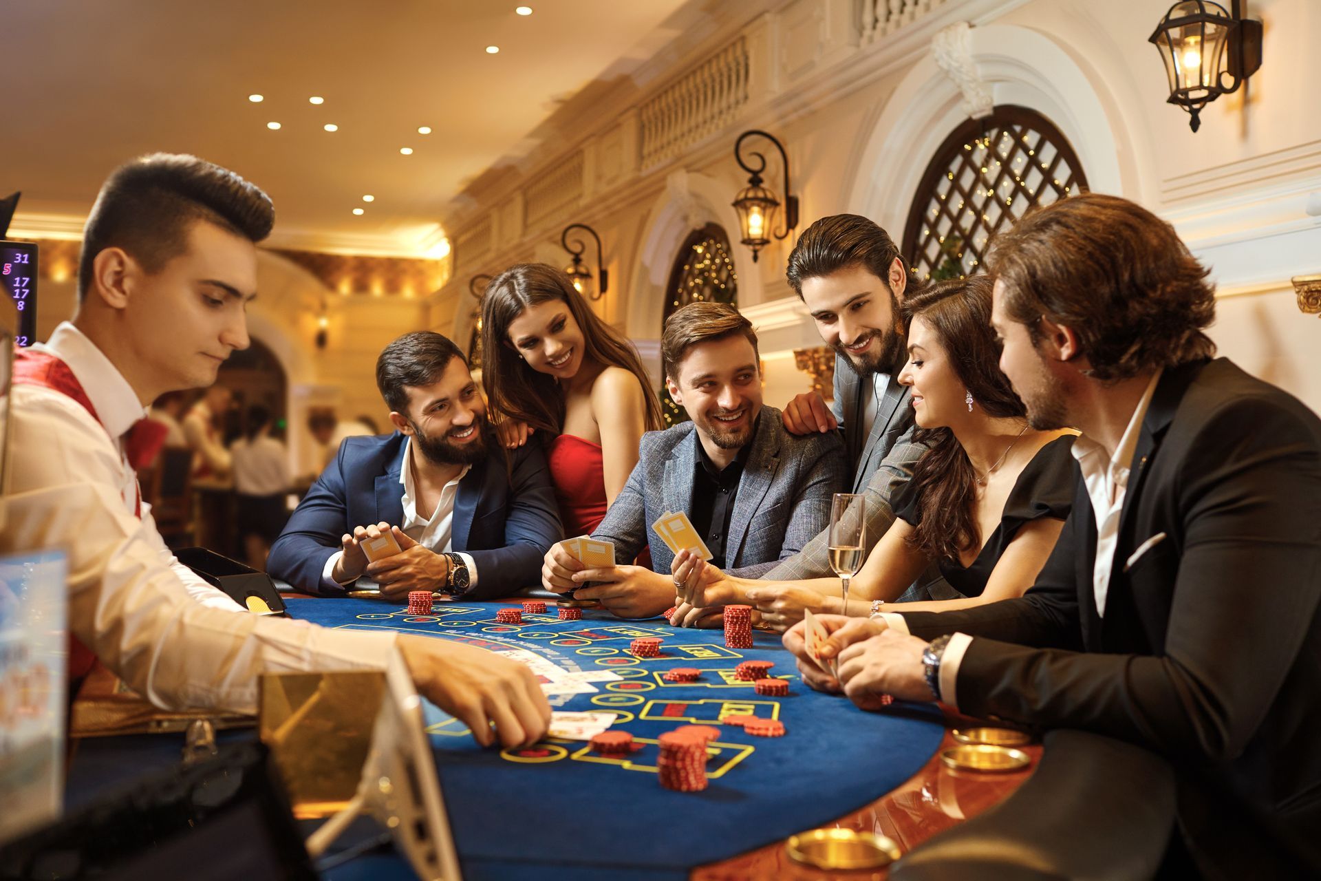 People playing cards at a casino table. Poker chips, smiles, well-dressed people, and an elegant interior.