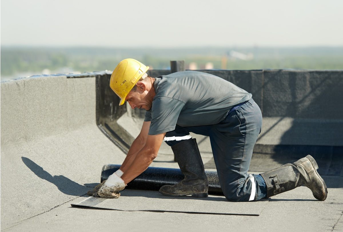 Roofing crew wearing safety equipment on a commercial project