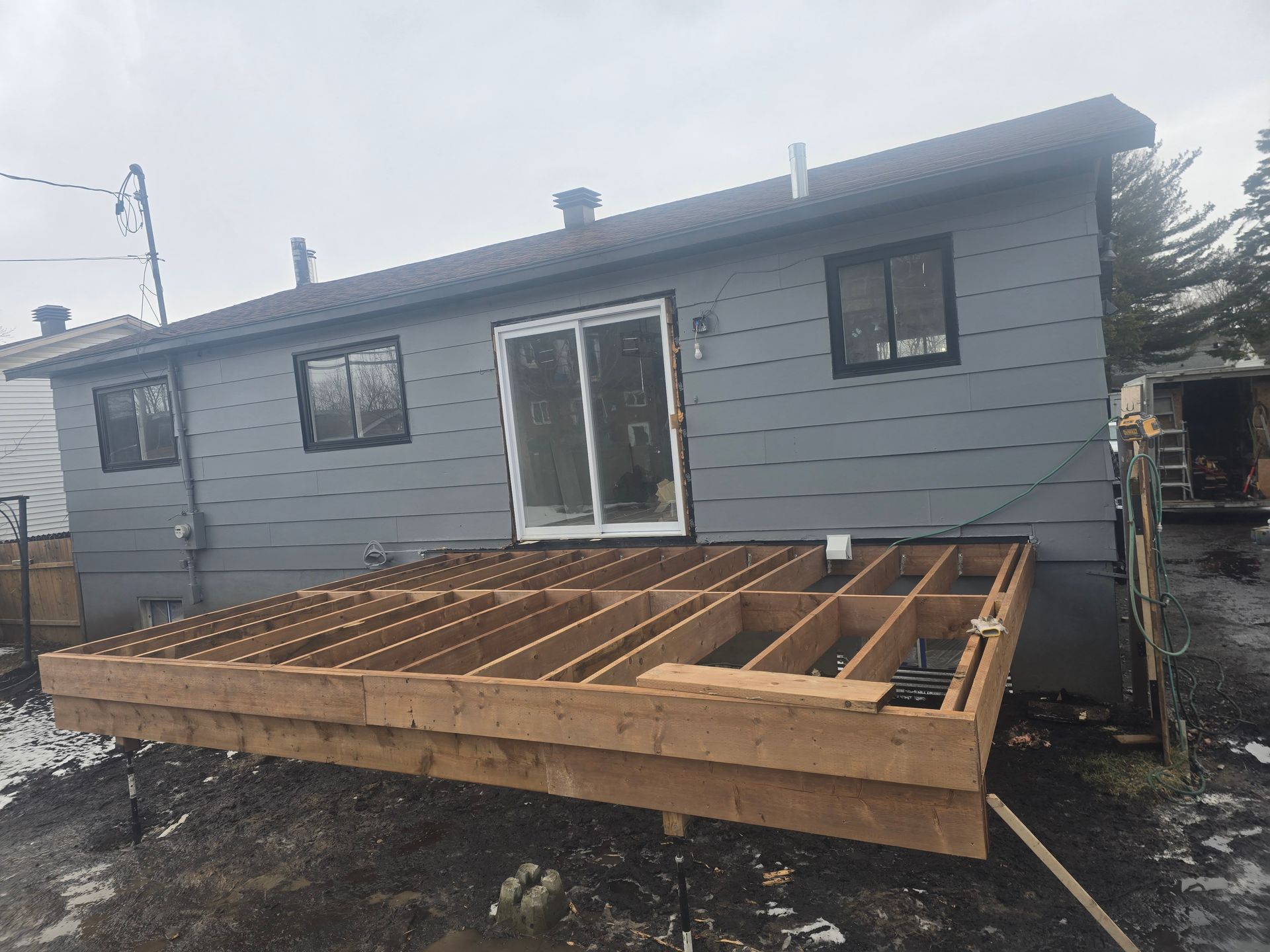 Une maison avec une terrasse en bois en construction devant elle.