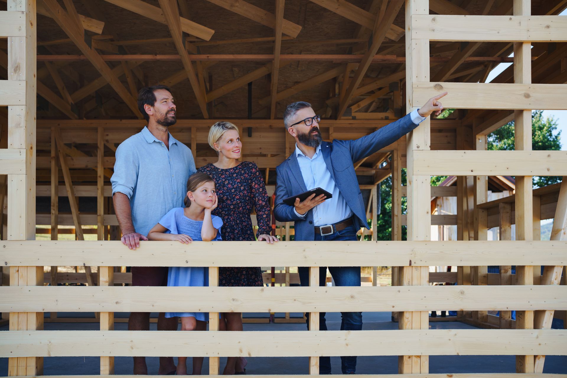 Une famille regarde une maison en construction.