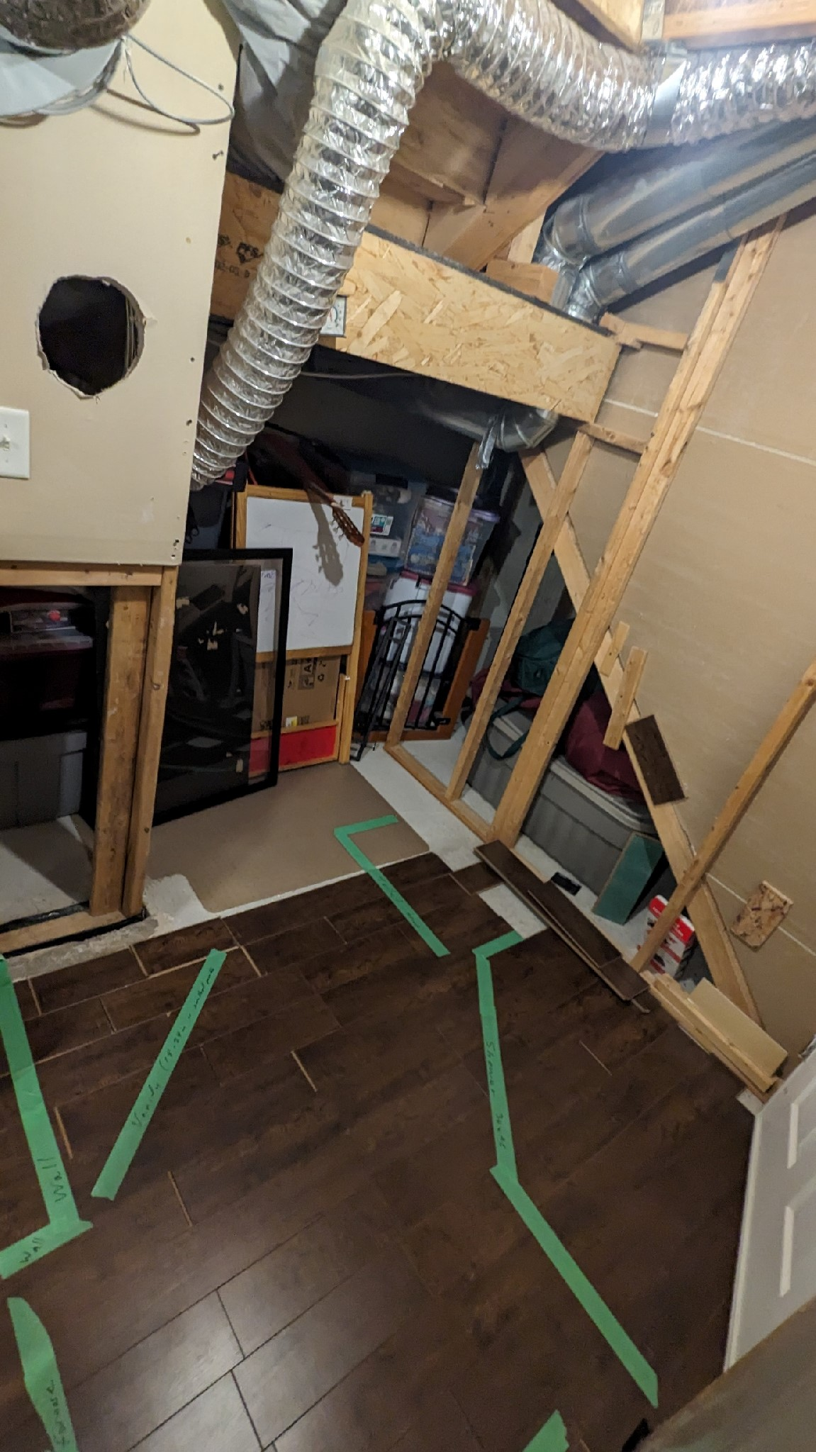 Une pièce avec un plancher en bois et du ruban adhésif vert sur le sol.