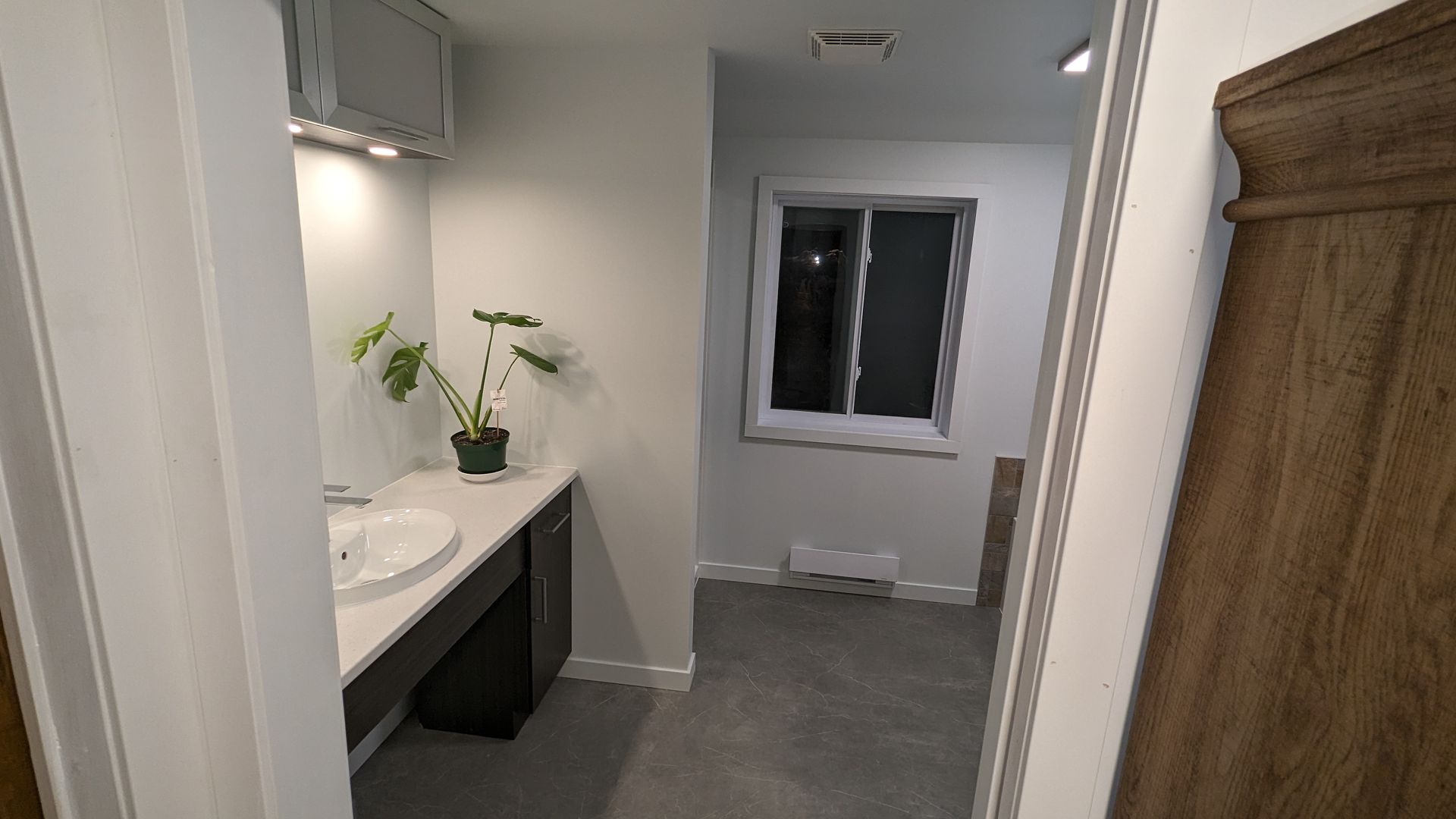Une salle de bain avec un lavabo et une fenêtre.