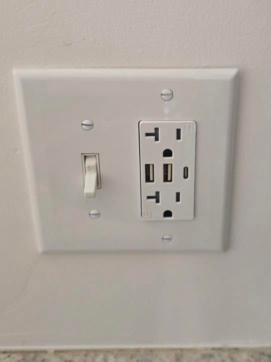 White wall plate with a light switch and a duplex electrical outlet.