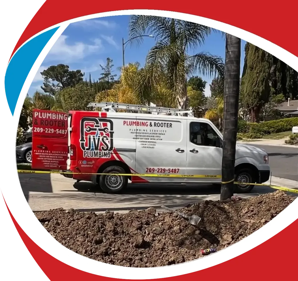 Plumbing service van parked on a residential street with trees and a yard in the background
