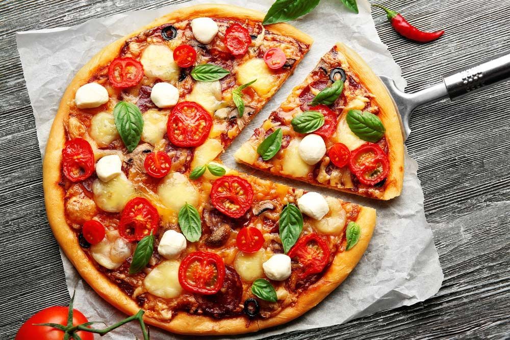 A Pizza With Tomatoes, Mozzarella, Basil and Pepperoni — Zachary's in Noosaville, QLD