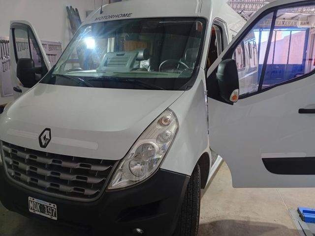 Furgoneta Renault blanca en el interior, con las dos puertas delanteras abiertas.
