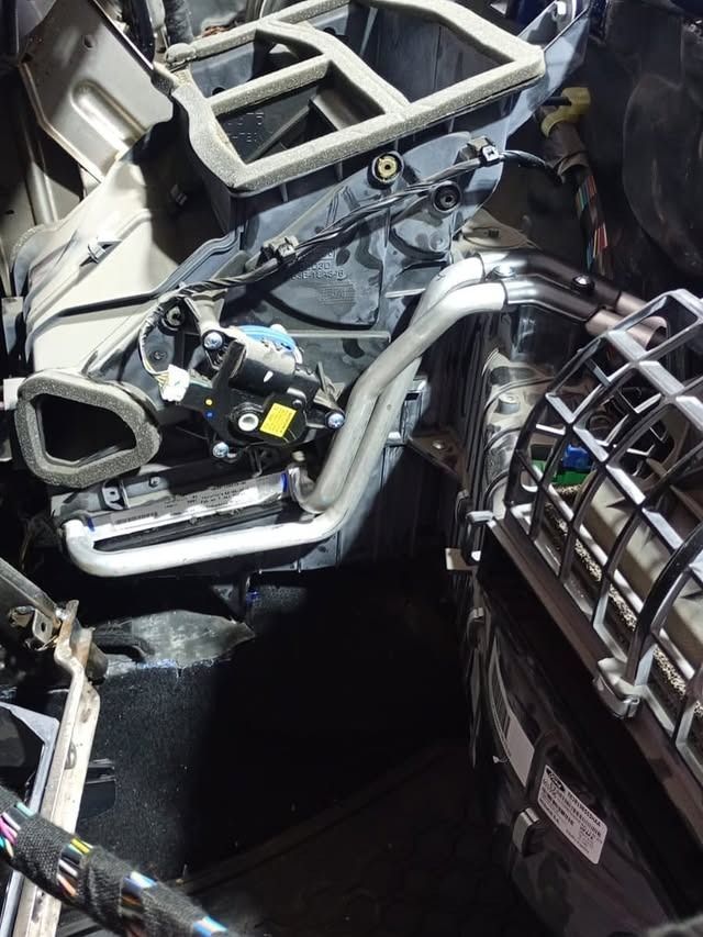 Tablero del coche desmontado, con el cableado, las rejillas de ventilación y la estructura metálica a la vista durante una reparación o inspección