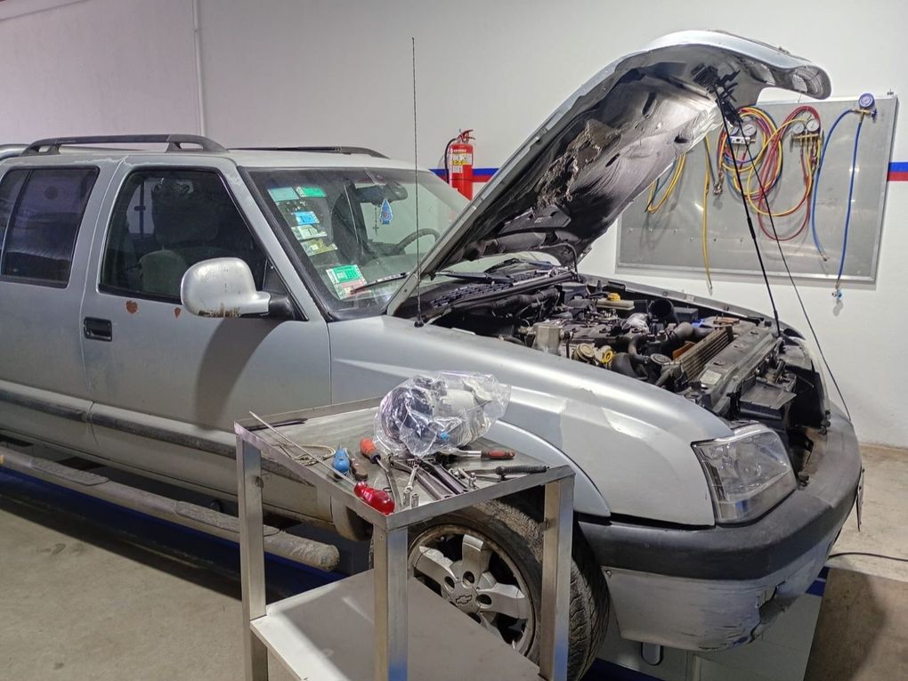 SUV plateado con el capó abierto en un taller, el motor a la vista y un equipo de diagnóstico conectado