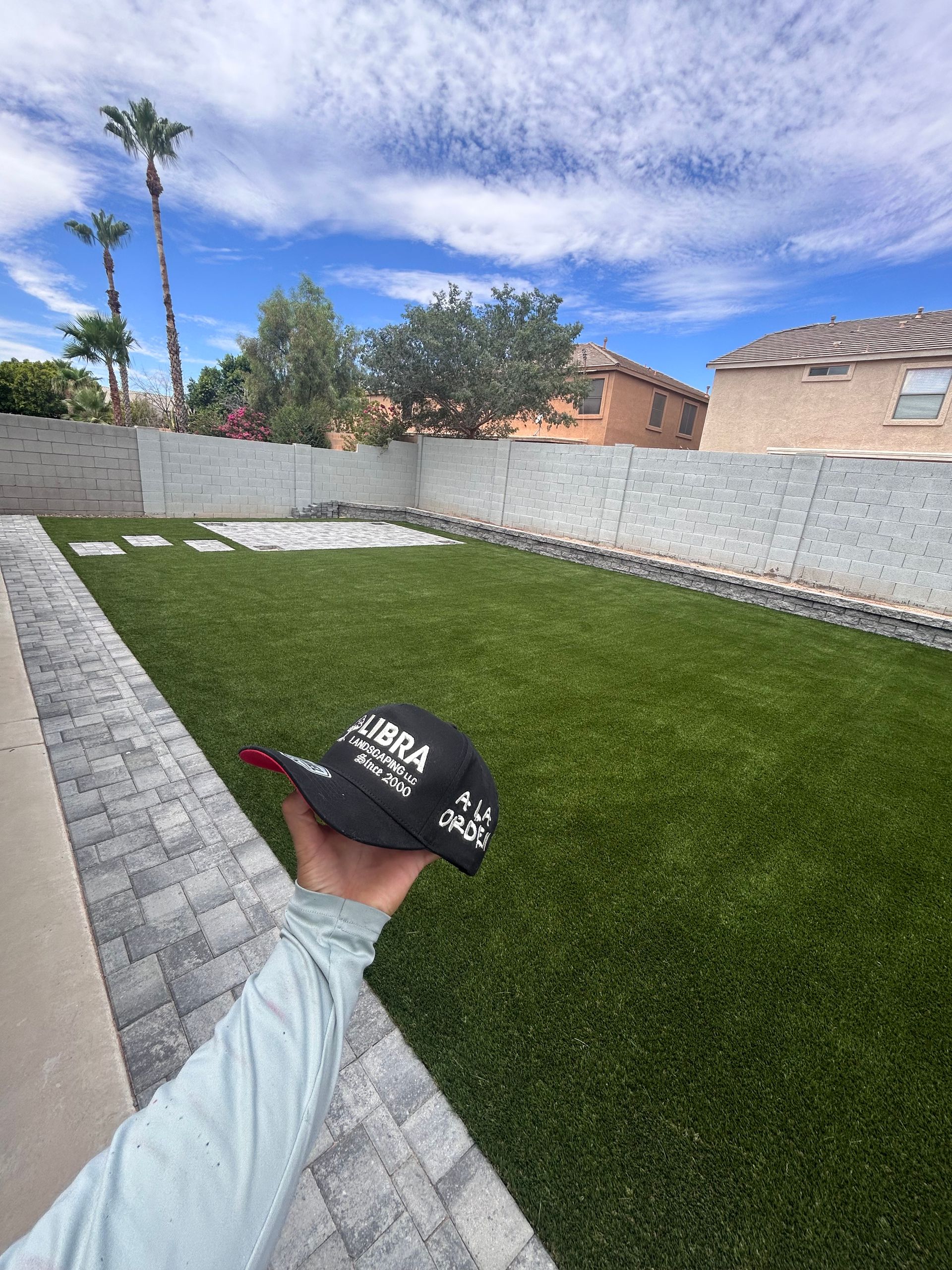 A large pile of grass is sitting in front of a house.