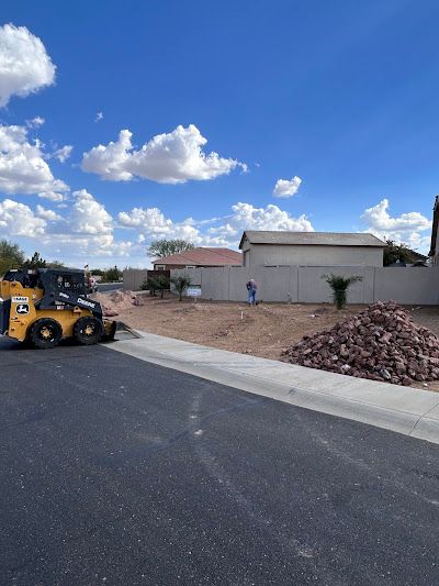 A bulldozer is driving down a street next to a pile of dirt.