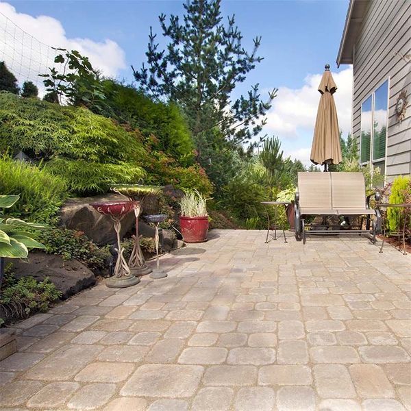A patio with chairs and an umbrella in front of a house