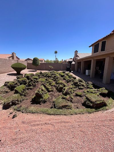 A large pile of grass is sitting in front of a house.