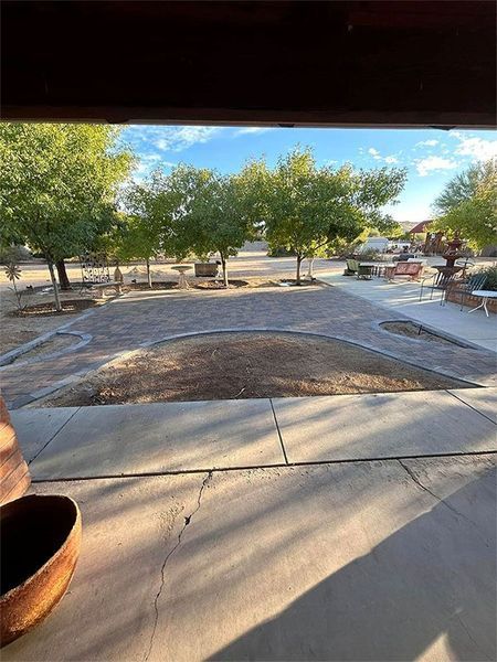 A view of a park from a window with trees in the background.