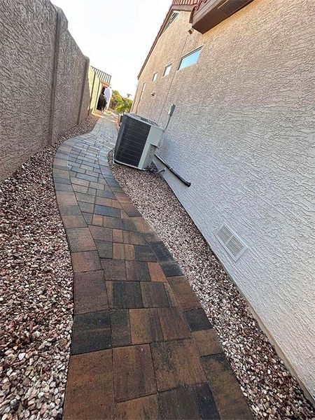 A sidewalk leading to a house with a brick walkway.