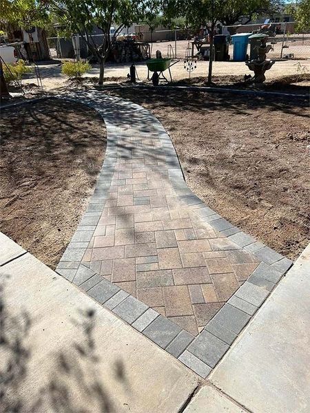 A brick walkway is being built in a park.