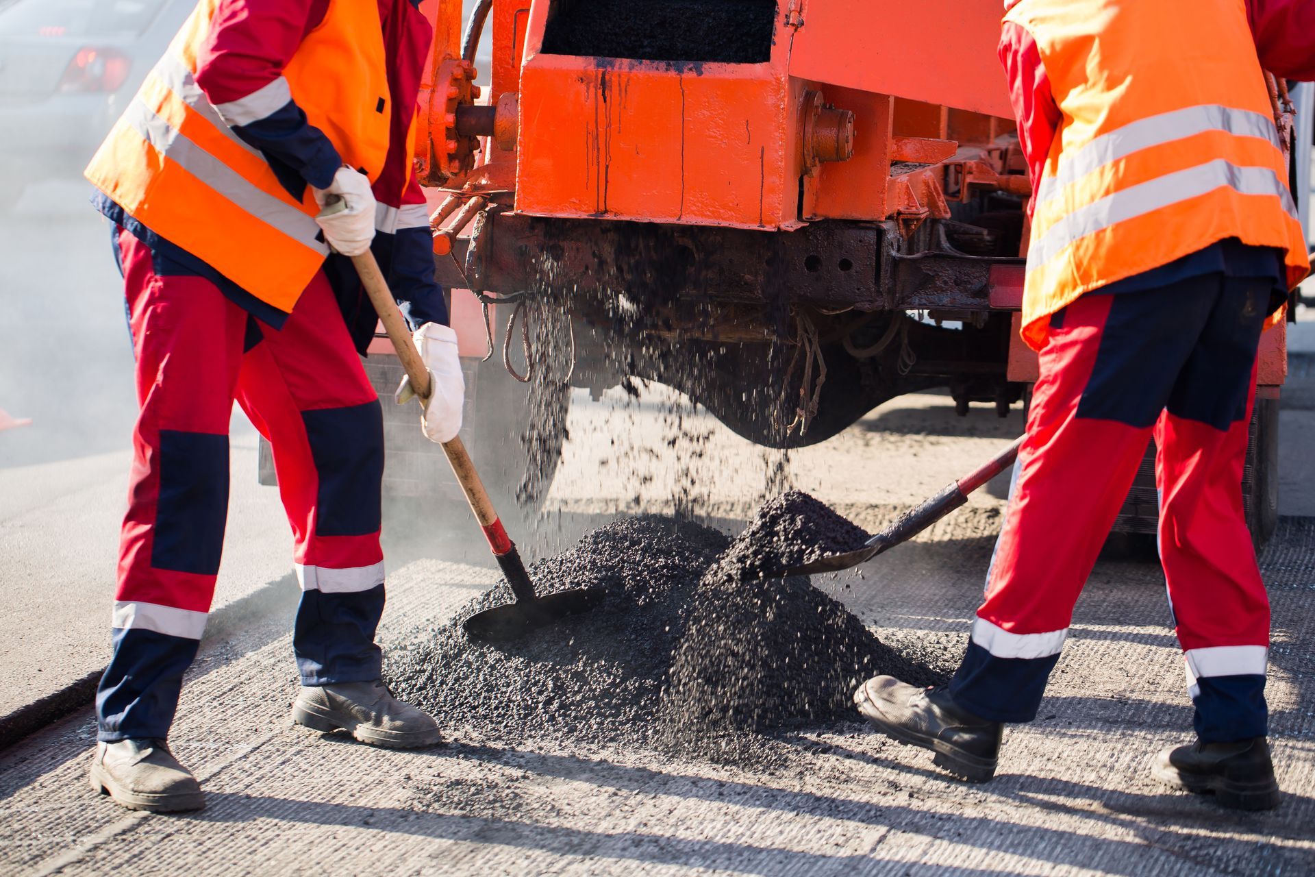 A group of construction workers are working on a road.