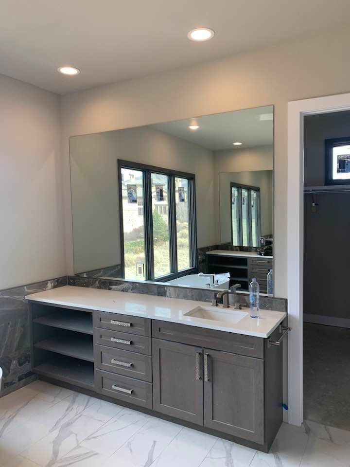 A bathroom with a large mirror and a sink.