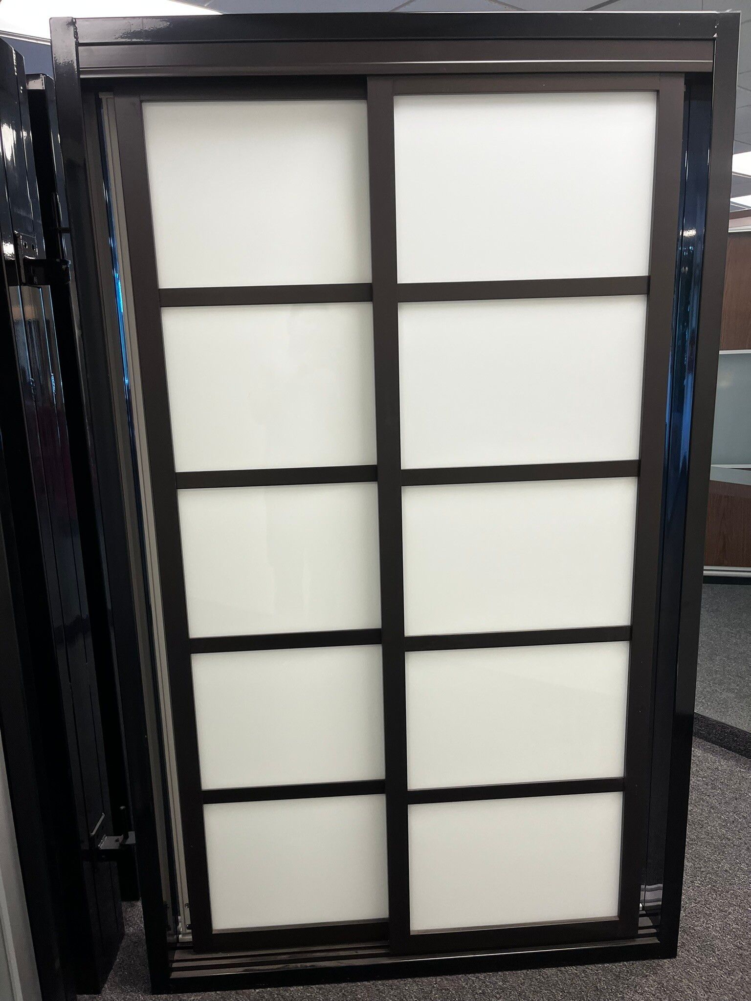 Black framed frosted glass panel with a grid of rectangular panes.