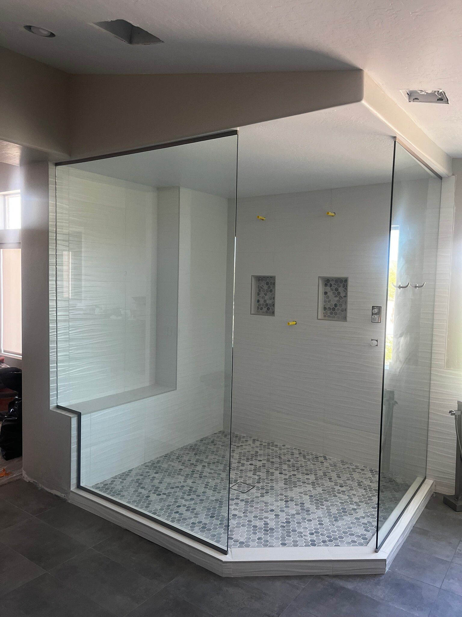 Modern glass-walled office booth with patterned floor and white interior walls