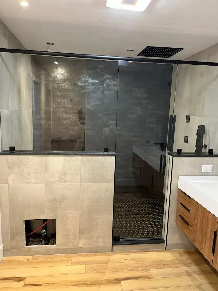 A bathroom with a walk in shower and a sink.