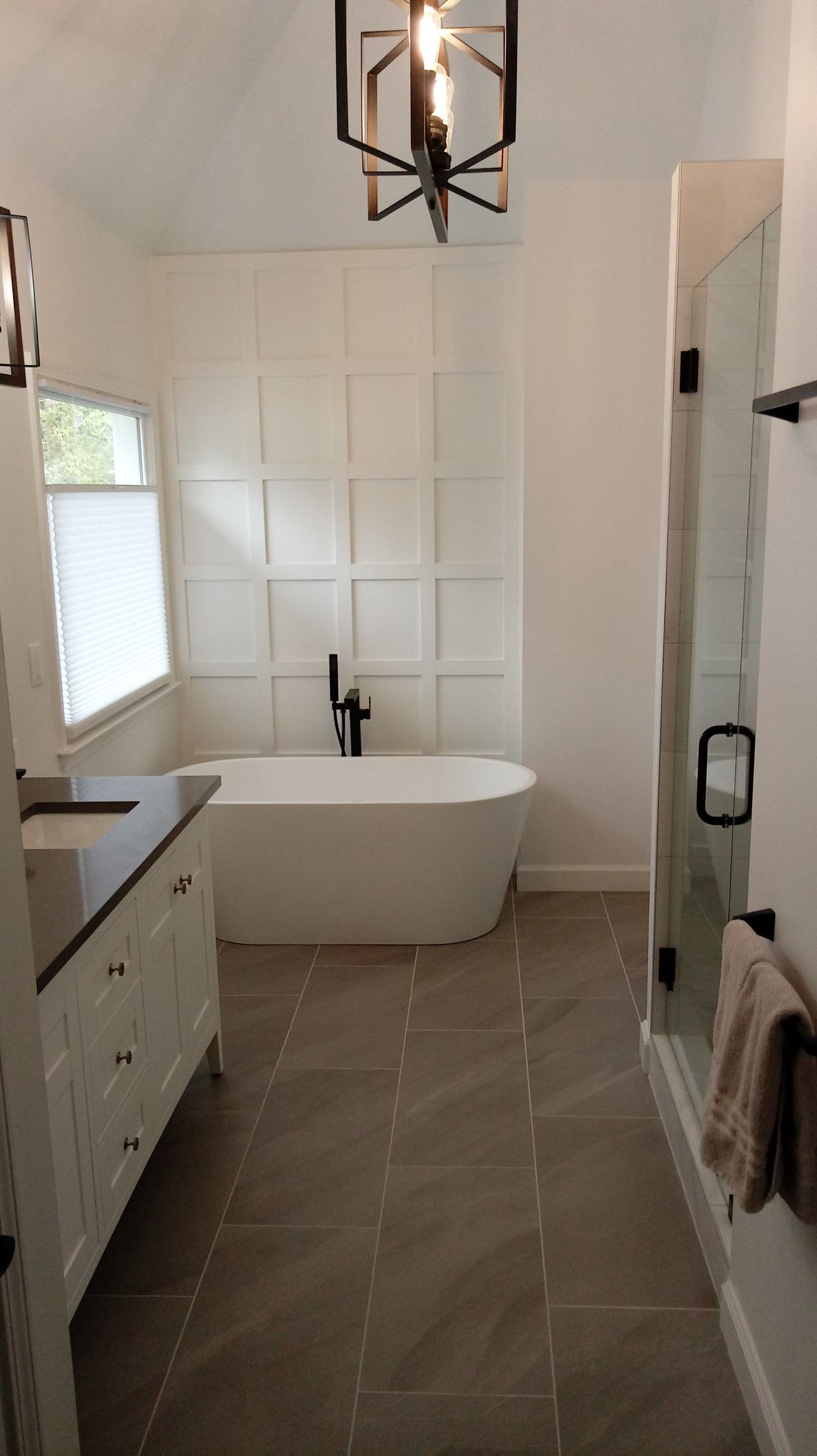 White marble-tile floor beside black-framed glass doors with sunlight reflections