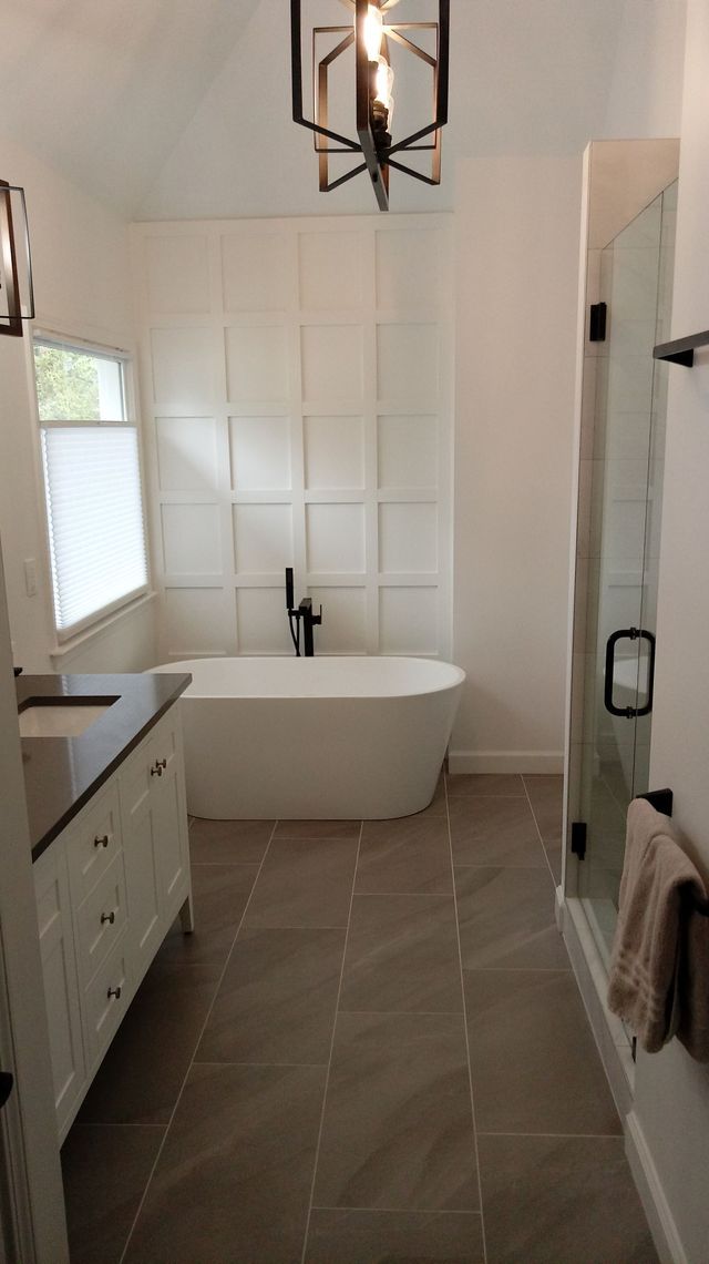 White marble-tile floor with gray veining beside black-framed glass doors and bright daylight reflections