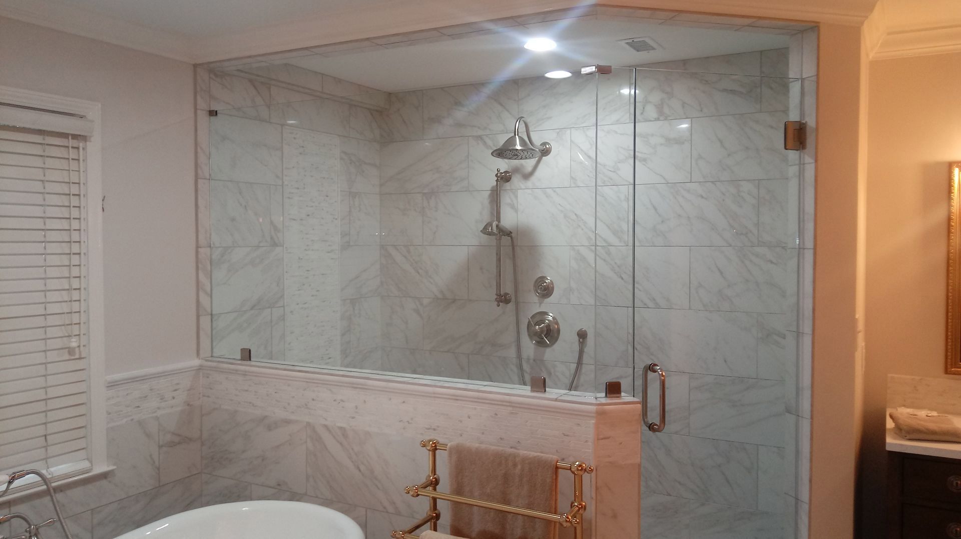 Bathroom with a tiled walk-in shower, glass door, and built-in bench