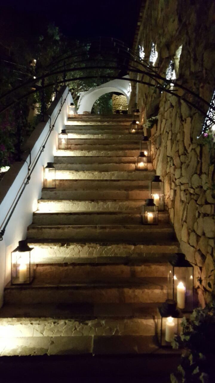 Die Treppe ist nachts beleuchtet und auf den Stufen befinden sich Laternen.