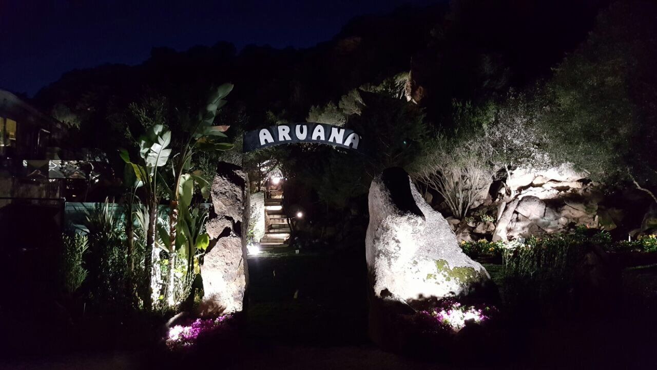 Der Eingang einer Höhle ist nachts beleuchtet.