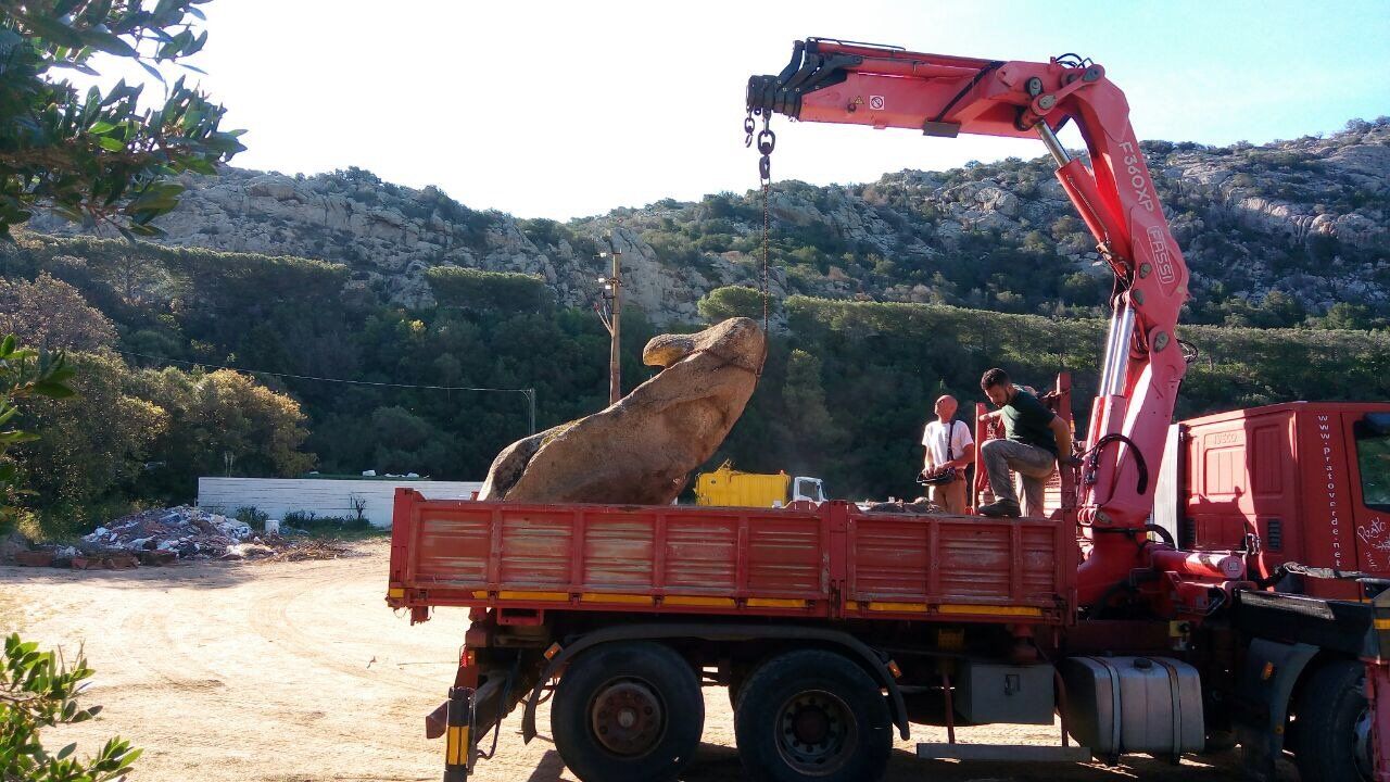 Eine große Löwenstatue steht auf der Ladefläche eines roten Lastwagens
