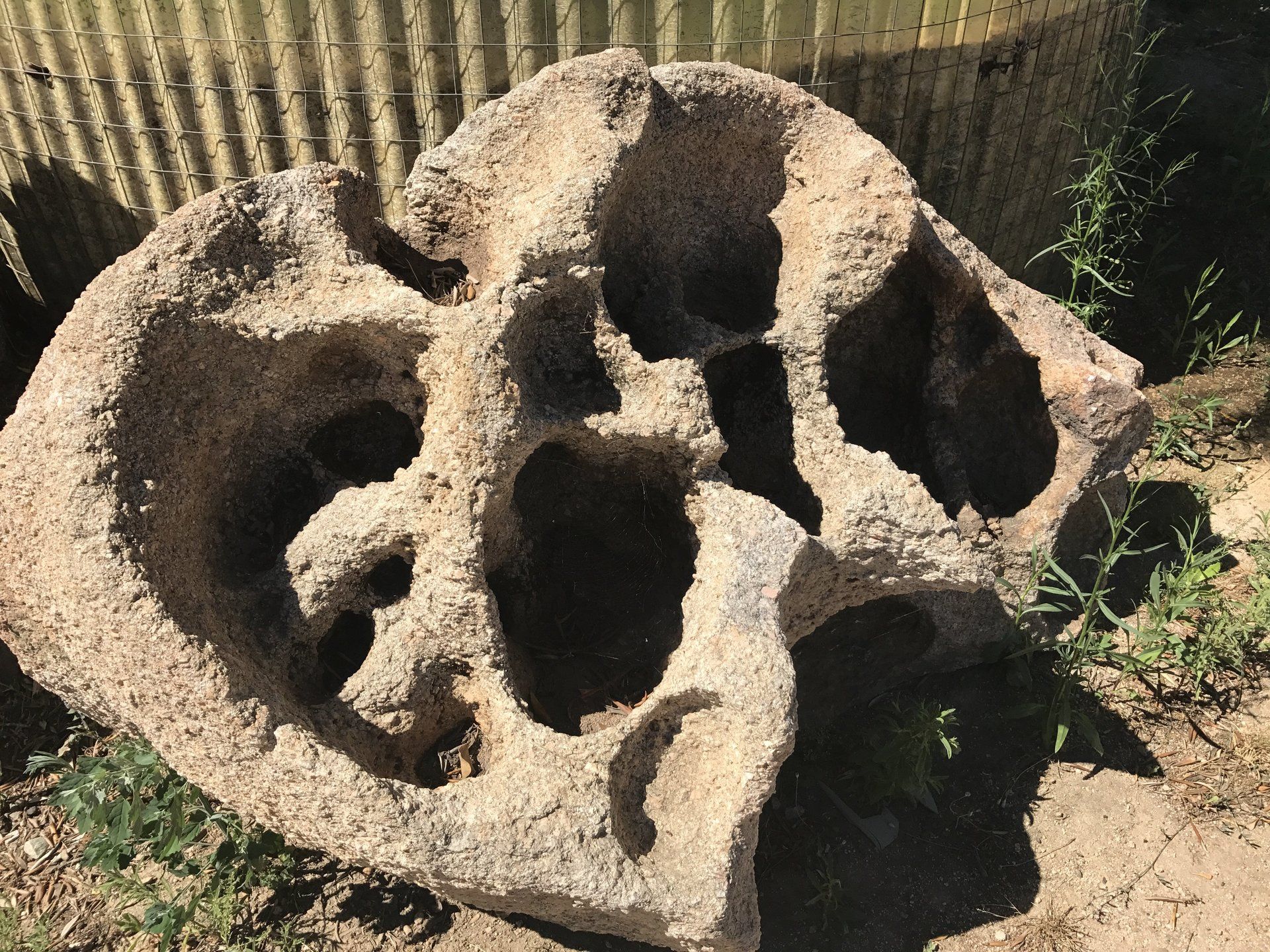 Ein großer Stein mit Löchern darin, der wie ein Totenkopf aussieht