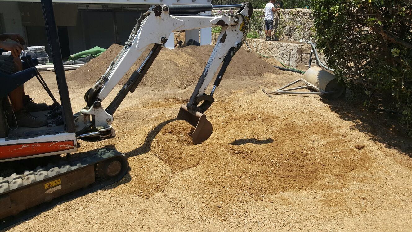 Un piccolo escavatore sta scavando una buca nella terra.