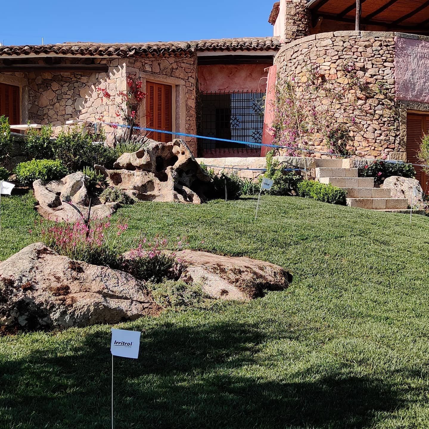 Una casa in pietra con un rigoglioso prato verde davanti