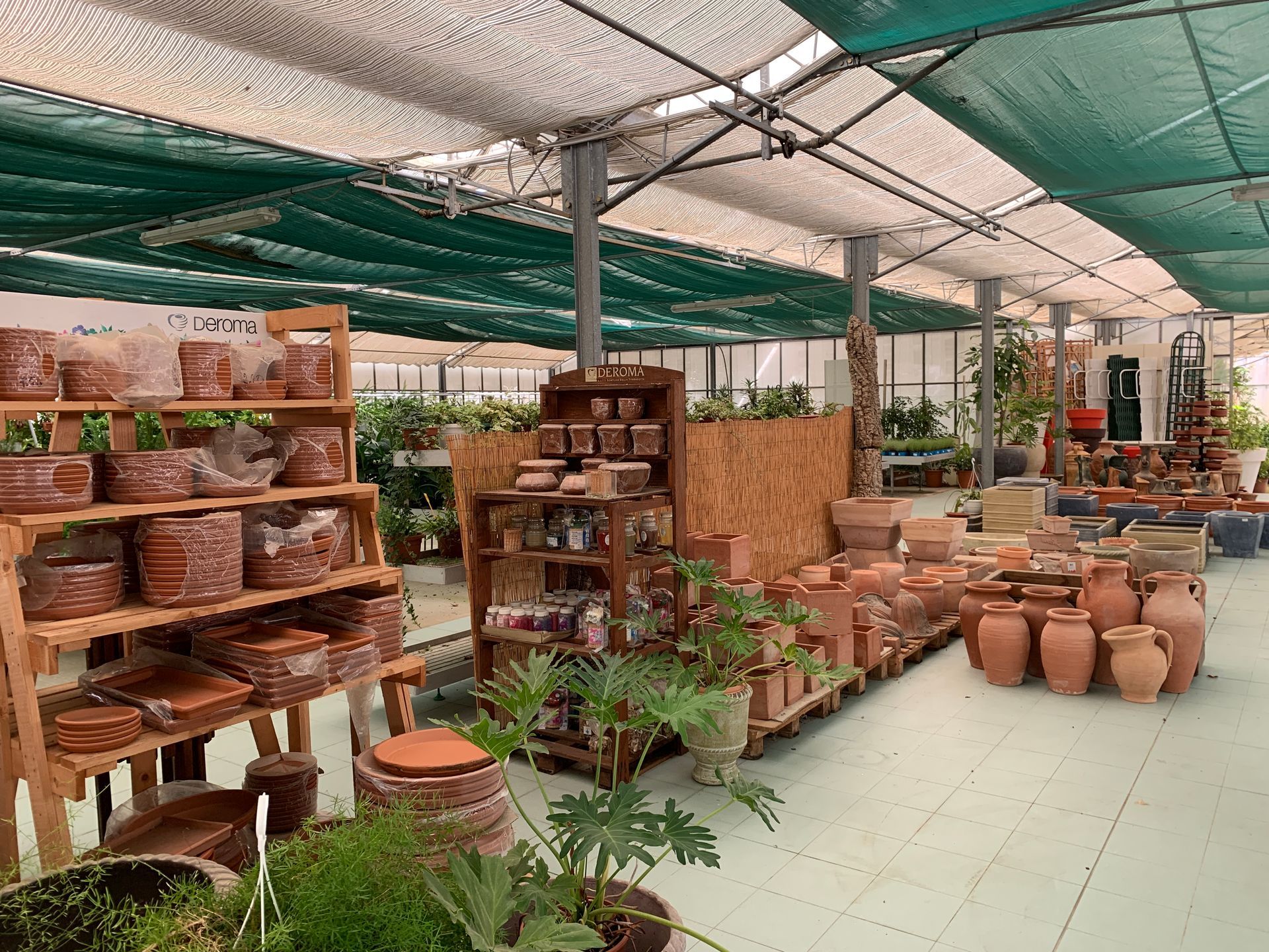 A greenhouse full of pots and plants.