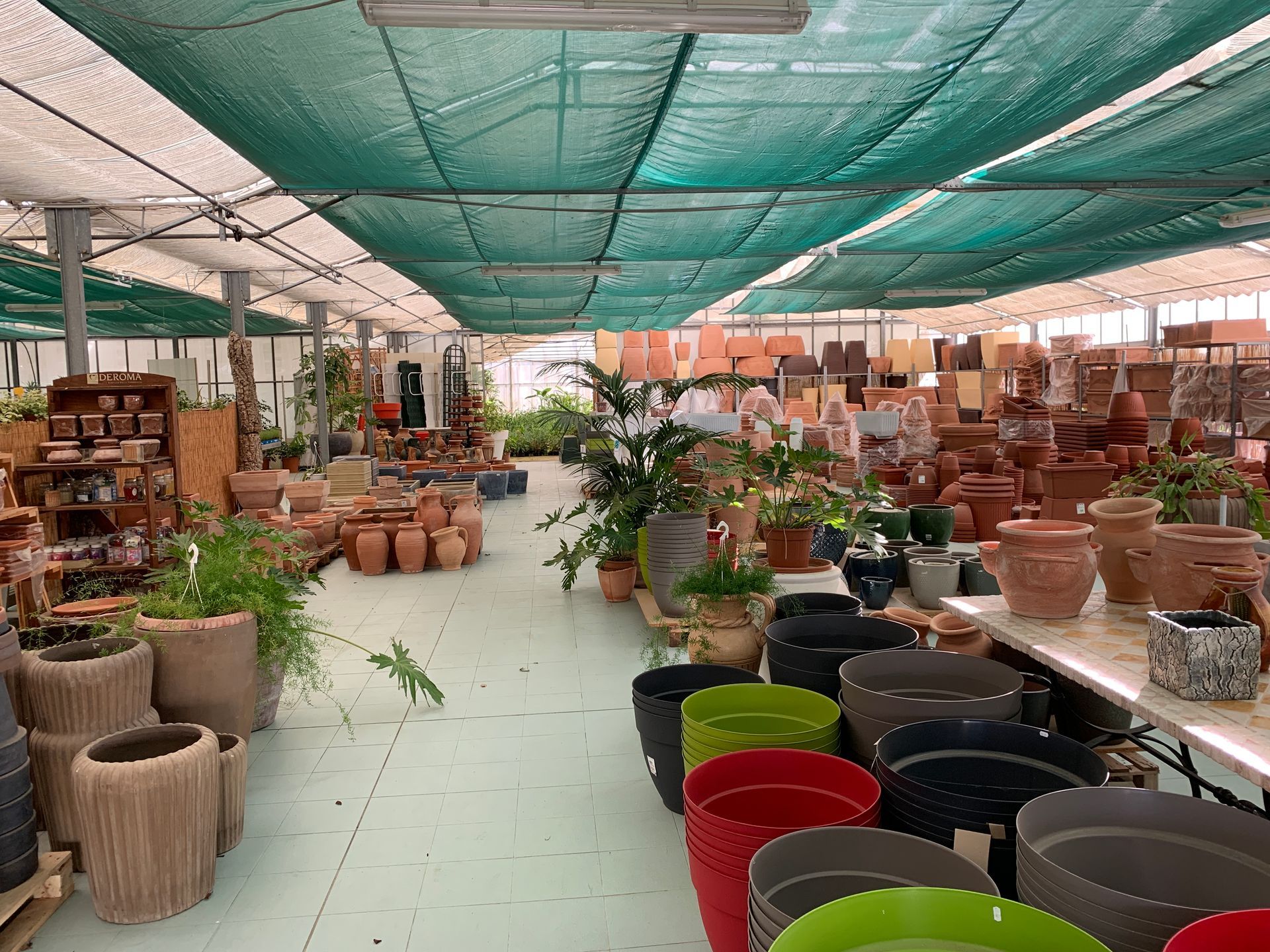 A greenhouse full of pots and plants.