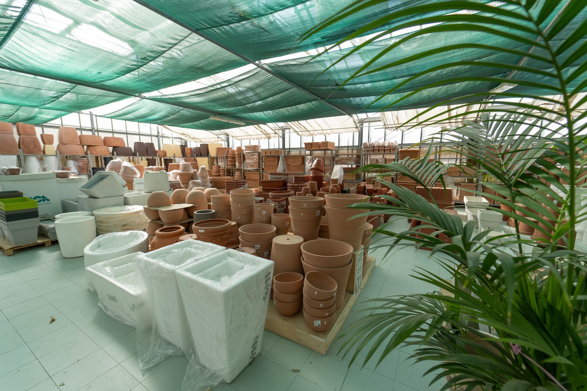 A greenhouse full of pots and plants.