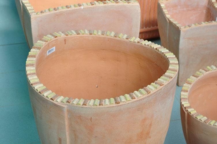 A group of terracotta pots placed one on top of the other on a table.