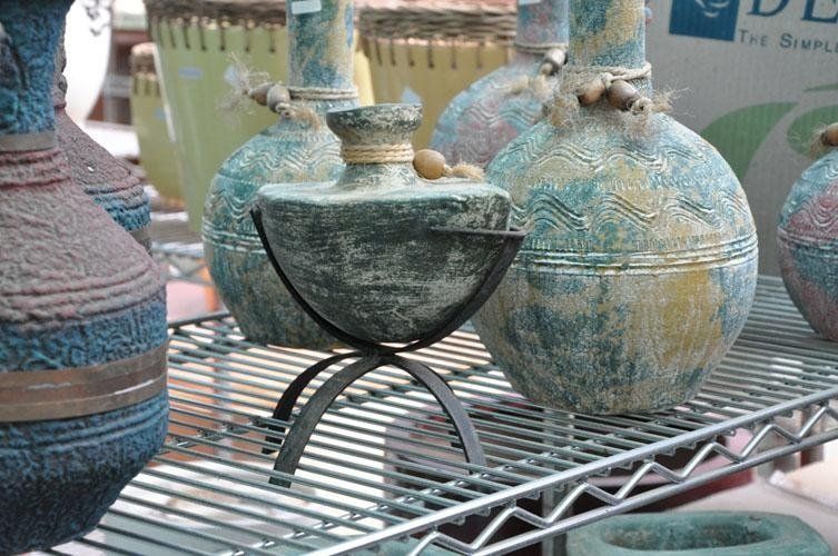 On a metal shelf sits a bunch of vases