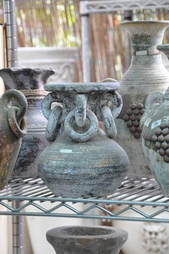 On a metal shelf sits a bunch of vases