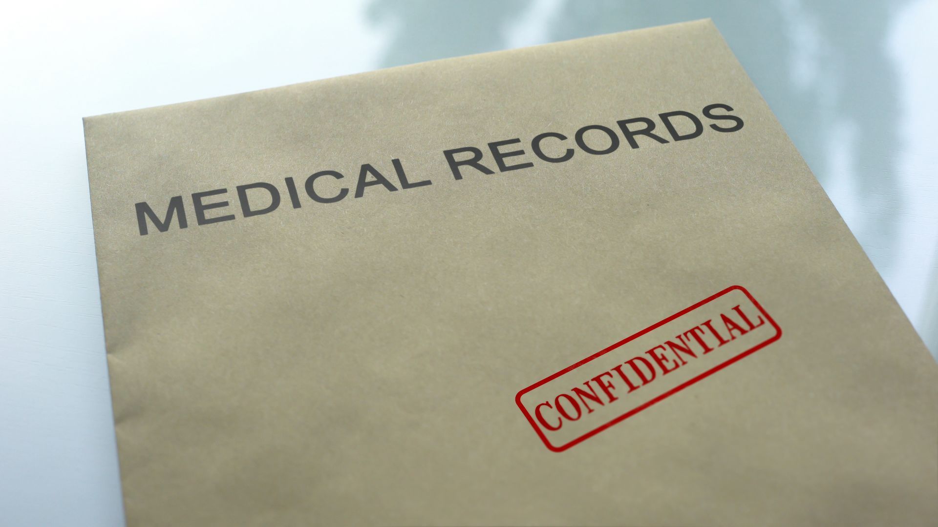 Medical records folder with a red CONFIDENTIAL stamp on a beige background