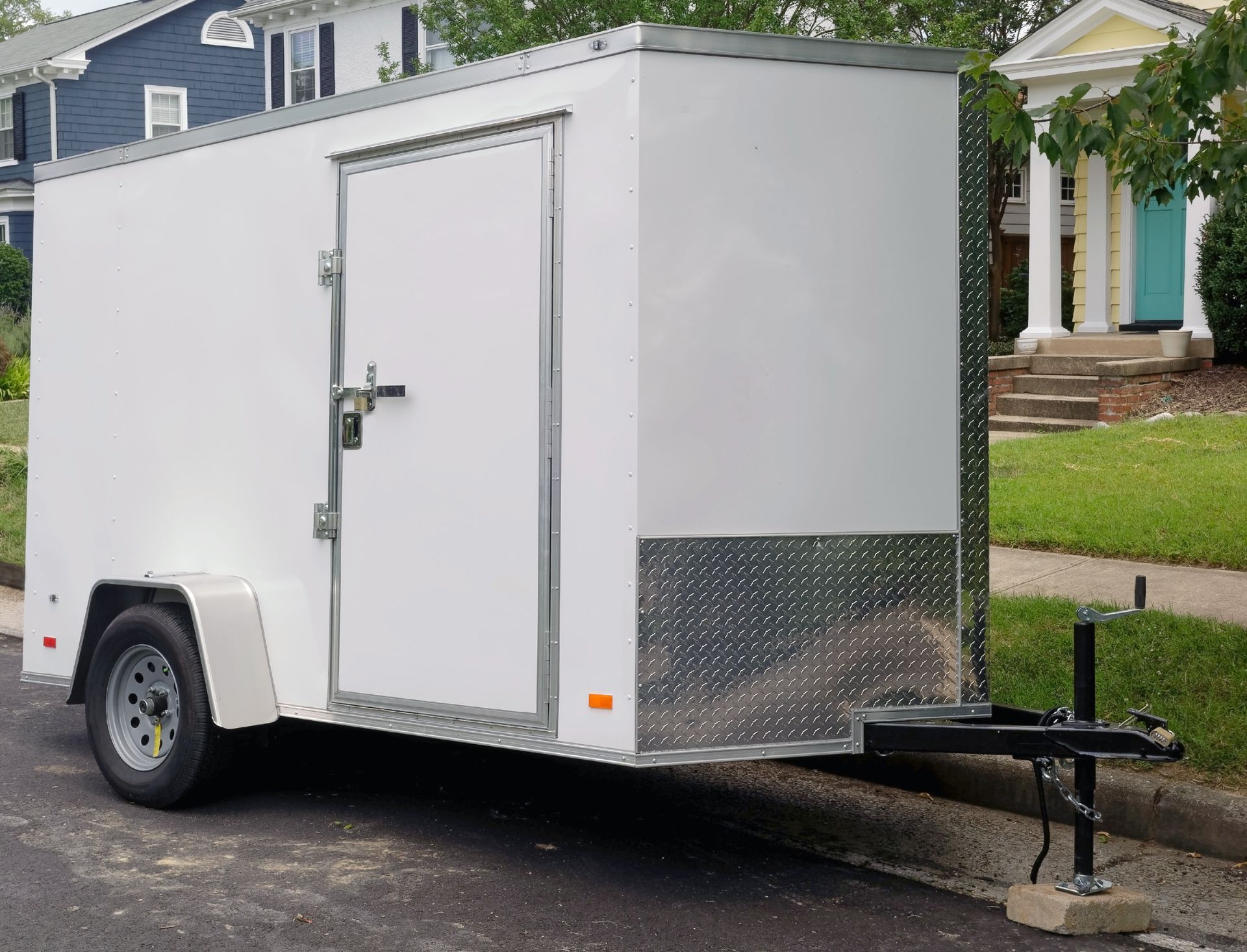 White cargo trailer parked on a street in a residential neighborhood