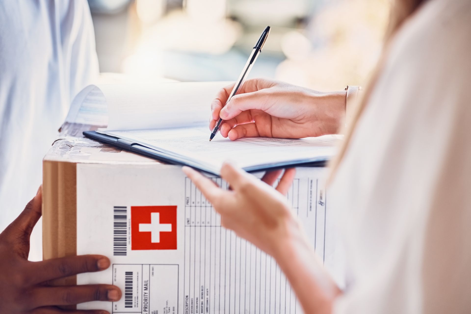 Doctors taking notes beside a clipboard with a red medical cross label
